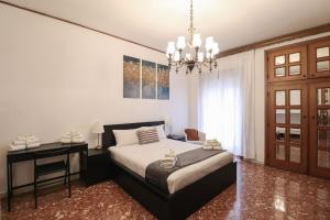een slaapkamer met een bed, een bureau en een kroonluchter bij Charming 2 Suite Apt - 20 min Colosseo & Metro 5 min in Rome