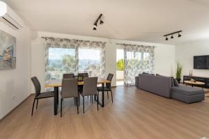 a living room with a table and chairs and a couch at Apartmani Ljubica in Duće