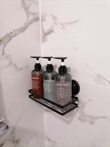 two bottles of soap on a shelf in a bathroom at Miquinhas Norte in Freamunde