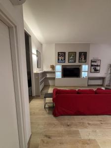 een woonkamer met een rode bank en een televisie bij Loft Altobelli in Rieti
