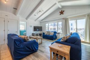 sala de estar con sofás azules y TV en D0311 The Sailfish. Private Pool, Hot Tub, Sound Views, Pool Table, Pets OK!, en North Point