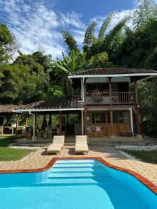eine Villa mit Swimmingpool und ein Haus in der Unterkunft Cabaña de Lujo con piscina privada en Pance, Cali in El Bosque