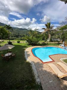 ein Swimmingpool in einem Hof mit Tisch und Stühlen in der Unterkunft Cabaña de Lujo con piscina privada en Pance, Cali in El Bosque + 4 Fotos