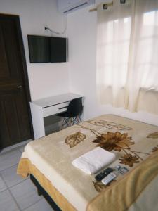 una camera con letto, scrivania e TV di Hotel e Churrascaria Major a Major