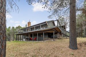 Deadwood Pines Hideaway في ستورجيس: منزل في الغابة مع شرفة التفاف