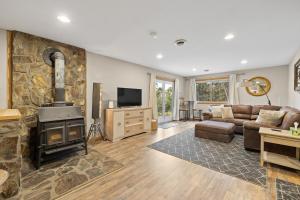 Deadwood Pines Hideaway في ستورجيس: غرفة معيشة مع أريكة ومدفأة