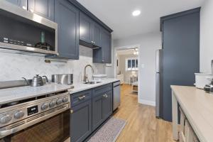 eine Küche mit blauen Schränken, einer Spüle und einem Herd in der Unterkunft 403 E 15Th Ave, Unit 2 in North Wildwood + 10 Fotos