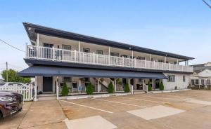 ein Gebäude mit einem Balkon und einem Auto auf einem Parkplatz in der Unterkunft 403 E 15Th Ave, Unit 2 in North Wildwood