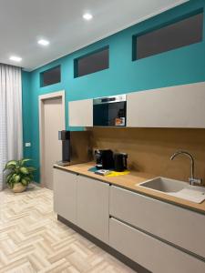 a kitchen with blue walls and a counter with a sink at Da Delfina Affittacamere in Anzio