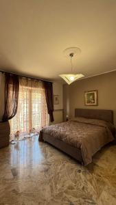 una camera da letto con un letto grande e una grande finestra di Emilia Tre appartamento con due camere a Piacenza