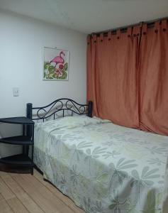 a bedroom with a bed with an orange curtain at El Recuerdo de Paipa, Boyacá, Colombia in El Manzano