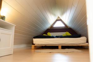 a bed in a small room with a ceiling at Bremen-Weyhe - peaceful - kitchen - wifi in Weyhe
