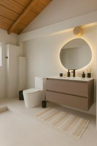 a bathroom with a toilet and a mirror at Beachfront house for 20 people in Vichuquén Lake +19 photos