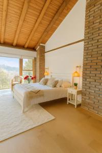 a bedroom with a large bed and a brick wall at Beachfront house for 20 people in Vichuquén Lake
