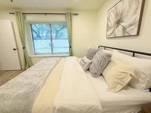 Modern and Cozy 3BR Retreat Perfect for Families or Big Group في سيدار بارك: غرفة نوم بسرير ابيض مع مخدات ونافذة