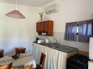 cocina con fregadero, mesa y fogones en Alquiler en Piriapolis, en Piriápolis 11 fotos más