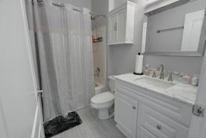 a bathroom with a shower and a toilet and a sink at Urban retreat- Quiet comfy 1 bedroom condo near LAX in Los Angeles +24 photos