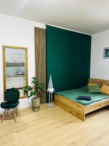 una camera da letto con un letto grande con una parete verde di Cztery Kąty w Rynku a Wałbrzych