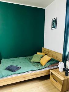 una camera con letto in legno e parete verde di Cztery Kąty w Rynku a Wałbrzych Altre 11 foto
