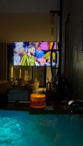 a tv in a living room with a swimming pool at استديو ميرا in Abha