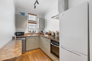 a kitchen with white cabinets and a counter top at The Signal - Stylish Deco Apt with Deck and Marina View in Picton