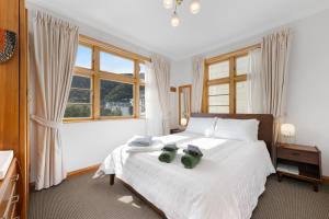 a bedroom with a bed with two green shoes on it at The Signal - Stylish Deco Apt with Deck and Marina View in Picton