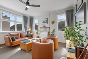 a living room with a couch and chairs and windows at The Signal - Stylish Deco Apt with Deck and Marina View in Picton