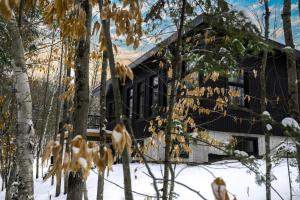 a house in the snow with trees in front at Le 4 sur le lac, Accès au lac, Boisée, BBQ in Wentworth