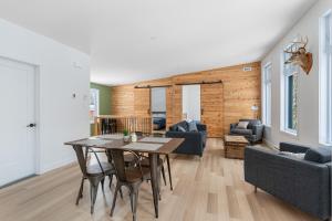 a dining room and living room with a table and chairs at Le 4 sur le lac, Accès au lac, Boisée, BBQ in Wentworth