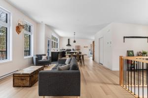 a living room with a couch and a table at Le 4 sur le lac, Accès au lac, Boisée, BBQ in Wentworth +32 photos