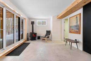 a living room with a wood stove in it at Le 4 sur le lac, Accès au lac, Boisée, BBQ in Wentworth