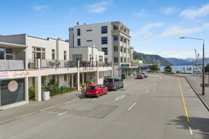 an empty street with cars parked on the side of a building at The Signal - Stylish Deco Apt with Deck and Marina View in Picton