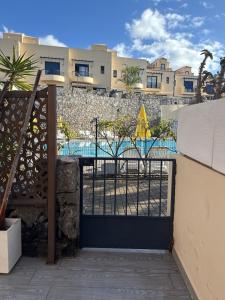 a gate with a pool behind a building at Gurugu Beach House in Palm-Mar