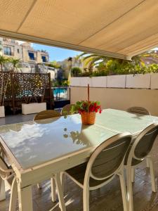 a white table with chairs and a plant on a patio at Gurugu Beach House in Palm-Mar