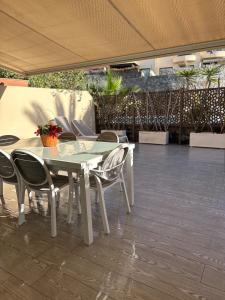 a glass table and chairs on a patio at Gurugu Beach House in Palm-Mar