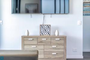 a dresser with a television on top of it at Ocean View 3 Bedroom with Great Facilities in Gold Coast