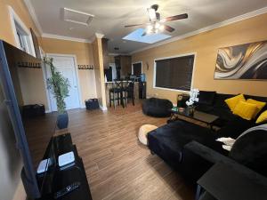 a living room with a black couch and a ceiling fan at Vacation Haven in Rolleville