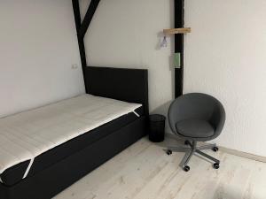 una piccola camera da letto con un letto e una sedia di 1 Zimmer Häuschen a Itzehoe