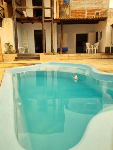 a large blue swimming pool in front of a building at Casa Petit Canoa Quebrada in Aracati