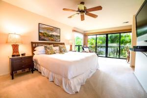 a bedroom with a bed and a ceiling fan at Wailea Ekahi 17D · WEK 17D Wailea Retreat w Ocean View Pool AC in Wailea +43 photos