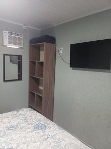 巴拉那瓜Pousada da Rê Ilha do Mel Encantadas的一间卧室，墙上有一张床和一台电视 更多4张照片