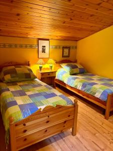 Un dormitorio con dos camas y techo de madera. en Accogliente attico vista Dolomiti, en Vodo Cadore