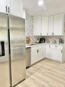 a kitchen with white cabinets and a stainless steel refrigerator at Modern cozy Home Palm Coast in Palm Coast +5 photos