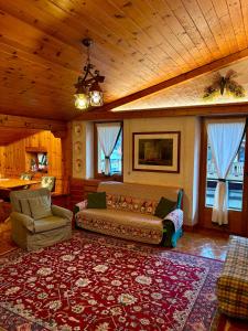 una sala de estar con un sofá y una alfombra en Accogliente attico vista Dolomiti, en Vodo Cadore