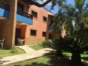 a building with a palm tree in front of it at CostaSol Pipa Chalés in Pipa