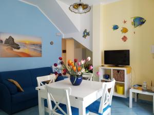 ein Wohnzimmer mit einem weißen Tisch und einem blauen Sofa in der Unterkunft Aurora Apartments and Spa in San Vito lo Capo