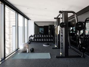a gym with a lot of equipment in a room at Novotel Perth Murray Street in Perth