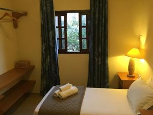 a bedroom with a bed with a towel on it at CostaSol Pipa Chalés in Pipa