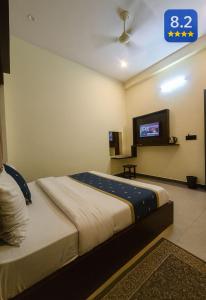 Un dormitorio con una cama con un televisor en la pared. en Hotel Clear View By Silverkey Hospitality, en Mathura