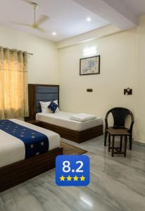 una habitación de hotel con dos camas y una silla en Hotel Clear View By Silverkey Hospitality, en Mathura